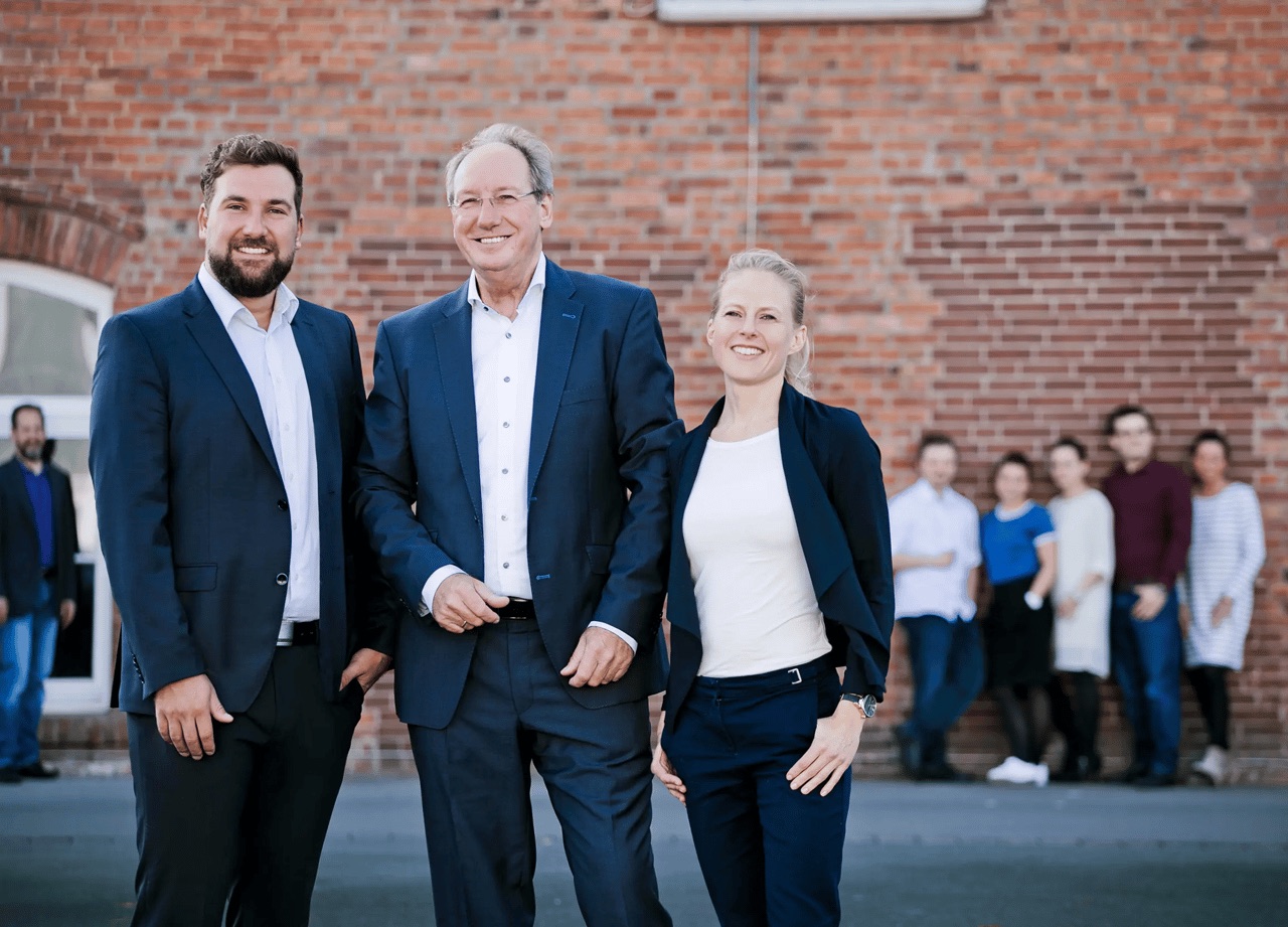 Die Familie Busche vor dem Firmengebäude, im Hintergrund das Team